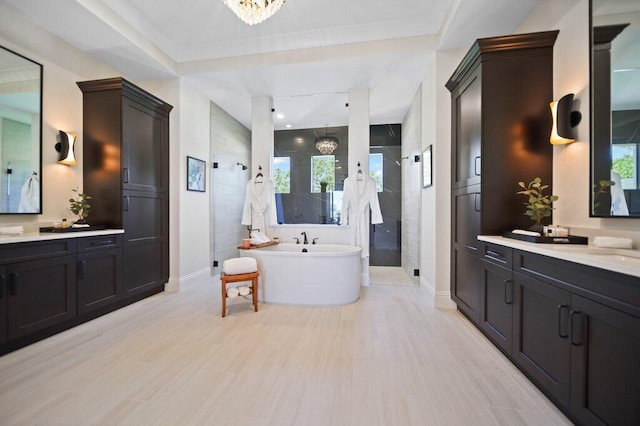 81 S River Rd, Stuart, FL 34996 - full bath featuring a freestanding tub, two vanities, a notable chandelier, baseboards, and a shower stall