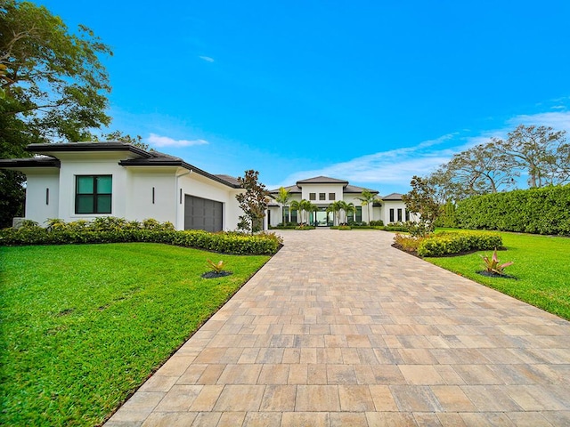 view of front of house with a garage and a front lawn