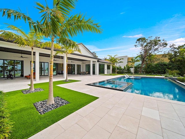 view of pool featuring an in ground hot tub, ceiling fan, a yard, and a patio area