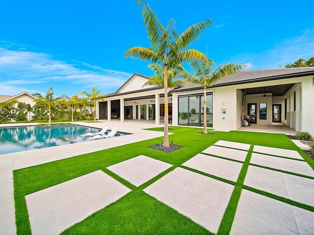 rear view of property with a patio, a yard, and ceiling fan