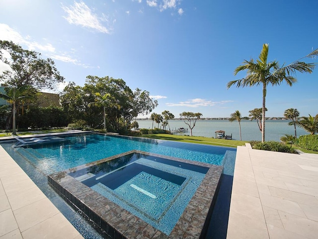 view of pool with an in ground hot tub and a water view