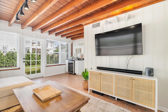 living room featuring light tile patterned floors, rail lighting, wine cooler, wooden ceiling, and beamed ceiling