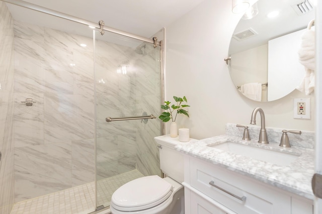 bathroom featuring vanity, toilet, and an enclosed shower