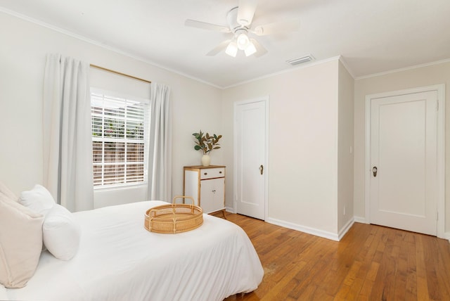 bedroom with crown molding, wood-type flooring, and ceiling fan