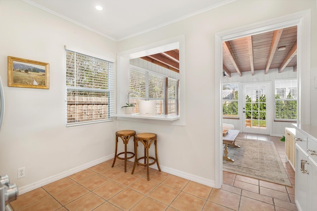 interior space featuring beam ceiling, light tile patterned flooring, and crown molding