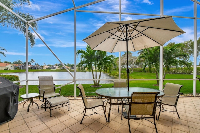 view of patio / terrace with a water view, grilling area, and glass enclosure