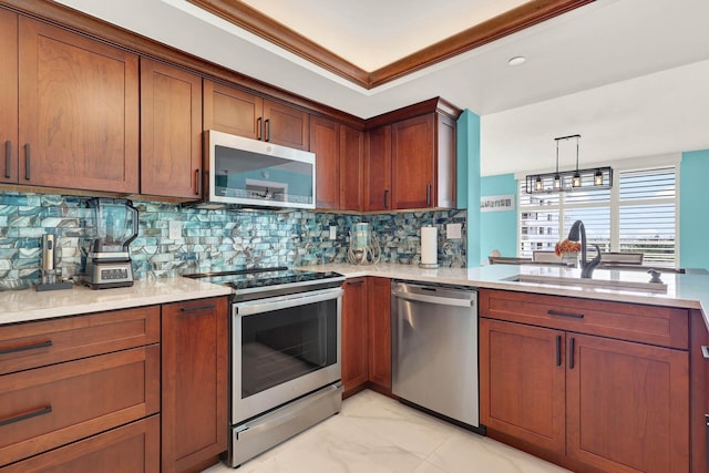 kitchen featuring decorative light fixtures, tasteful backsplash, sink, ornamental molding, and stainless steel appliances