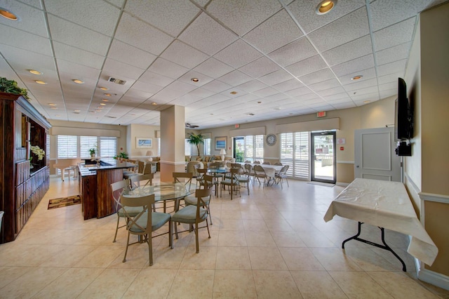 tiled dining area featuring a paneled ceiling