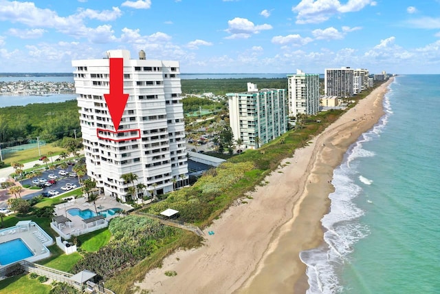 birds eye view of property with a water view and a beach view