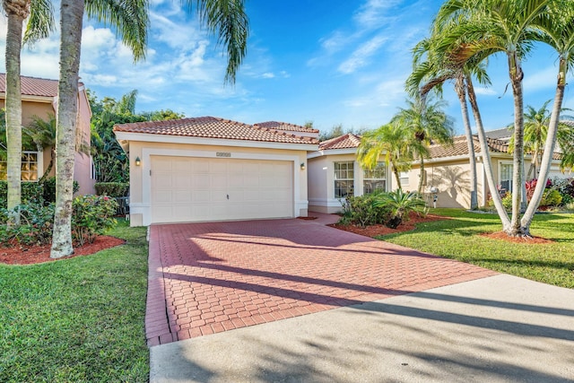 mediterranean / spanish-style house featuring a garage and a front lawn