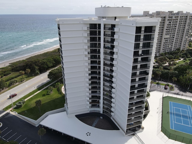 view of building exterior with a water view and a beach view