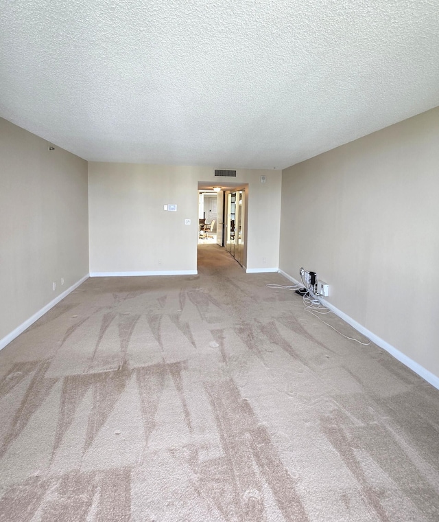 carpeted spare room featuring a textured ceiling