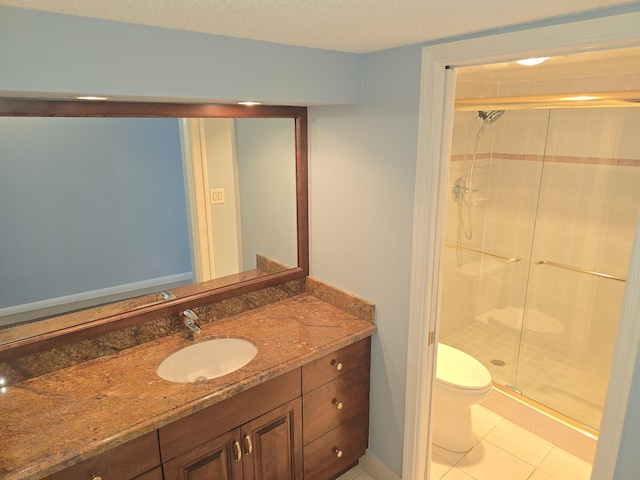 bathroom with walk in shower, vanity, tile patterned floors, and toilet