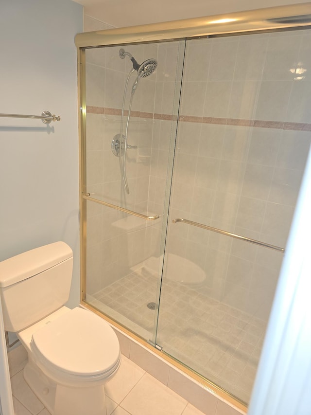 bathroom with walk in shower, toilet, and tile patterned flooring