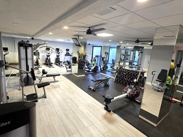 exercise room with a paneled ceiling and ceiling fan