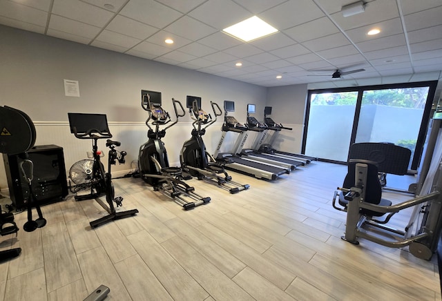 gym featuring a drop ceiling and light wood-type flooring