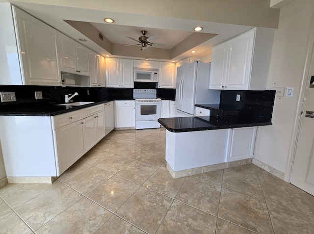 kitchen with white cabinetry, kitchen peninsula, white appliances, and a tray ceiling