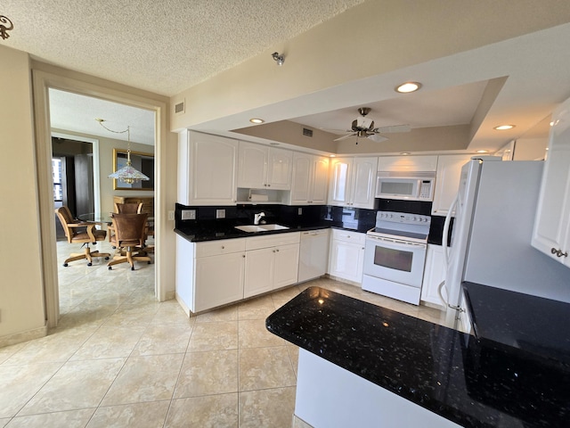 kitchen featuring sink, white cabinetry, light tile patterned floors, a raised ceiling, and white appliances