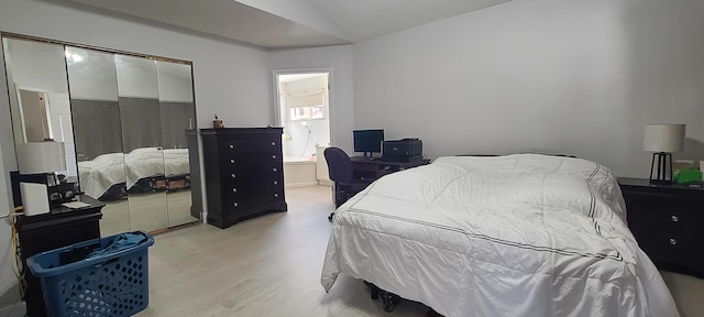 bedroom with vaulted ceiling and light hardwood / wood-style floors