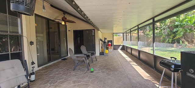 unfurnished sunroom with ceiling fan