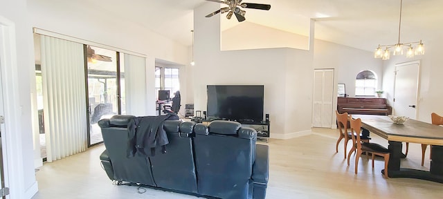 living room featuring ceiling fan, light hardwood / wood-style floors, and high vaulted ceiling