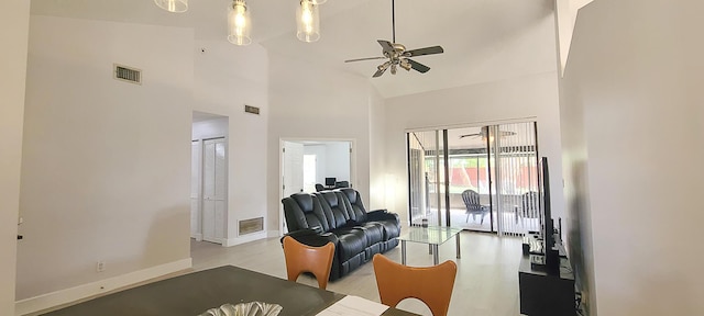 living room with high vaulted ceiling, ceiling fan, and light hardwood / wood-style flooring