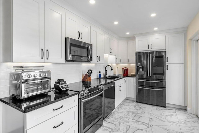 kitchen featuring tasteful backsplash, appliances with stainless steel finishes, sink, and white cabinets