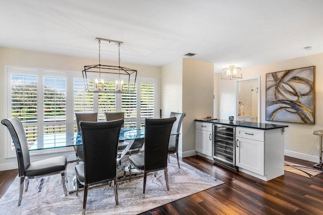 dining room with dark wood-type flooring, beverage cooler, a chandelier, and plenty of natural light