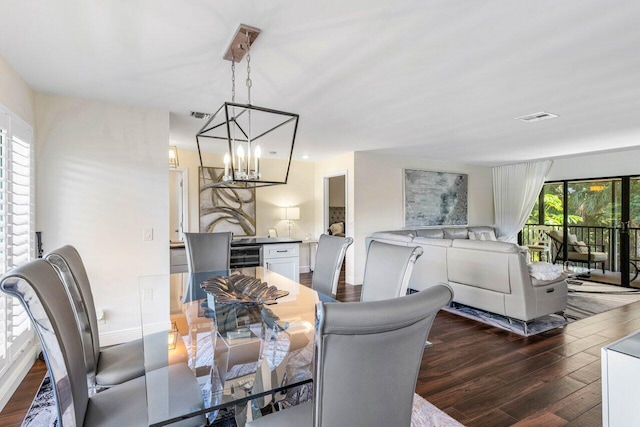 dining space with dark hardwood / wood-style flooring and a chandelier