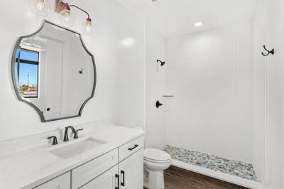 bathroom with vanity, hardwood / wood-style flooring, a shower, and toilet