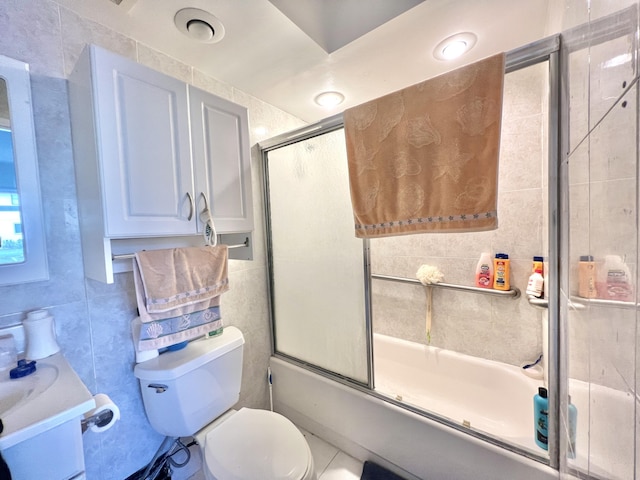 full bathroom with tile walls, backsplash, enclosed tub / shower combo, vanity, and toilet