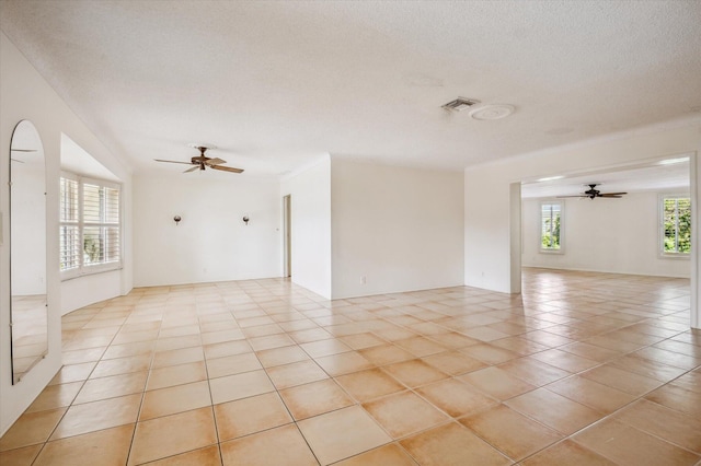 tiled spare room with ceiling fan and a textured ceiling