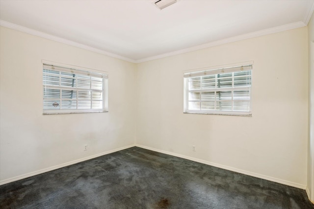 carpeted spare room featuring plenty of natural light and ornamental molding