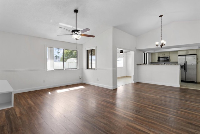 unfurnished living room featuring lofted ceiling, ceiling fan with notable chandelier, a textured ceiling, and dark hardwood / wood-style flooring