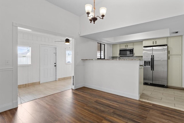 kitchen with hardwood / wood-style floors, a wealth of natural light, stainless steel appliances, and kitchen peninsula