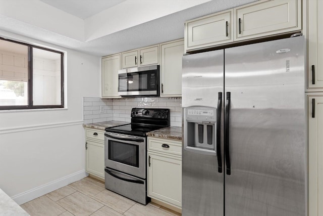 kitchen featuring decorative backsplash, stainless steel appliances, and cream cabinetry