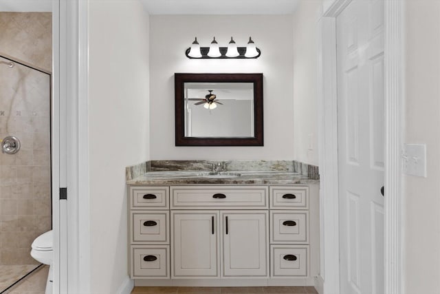 bathroom with vanity, a tile shower, tile patterned floors, and toilet