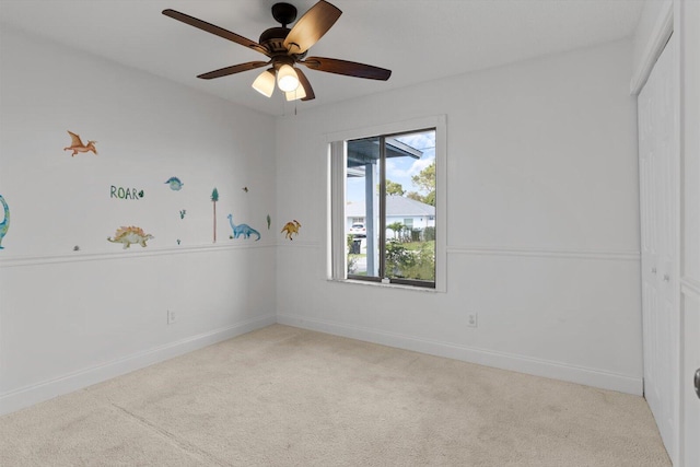 carpeted spare room with ceiling fan