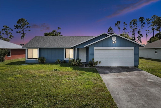 single story home featuring a garage and a lawn