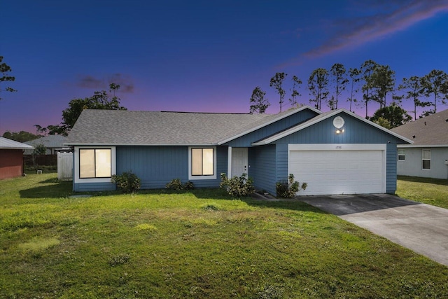 ranch-style house featuring a garage and a yard