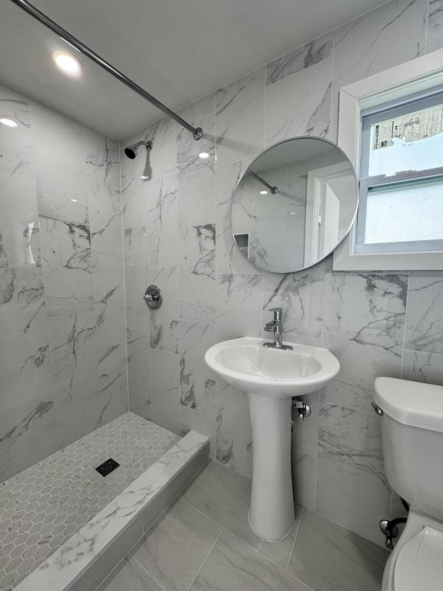 bathroom featuring a tile shower and toilet