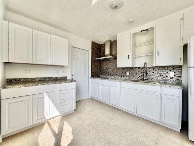 kitchen with sink, white cabinets, backsplash, white refrigerator, and wall chimney exhaust hood