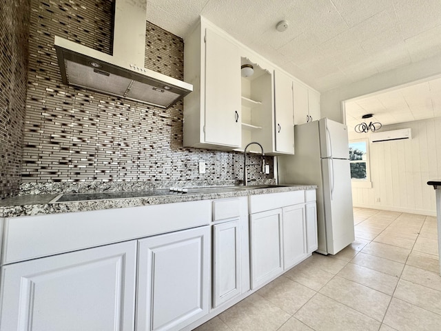 kitchen with white cabinetry, sink, a wall mounted AC, and wall chimney exhaust hood