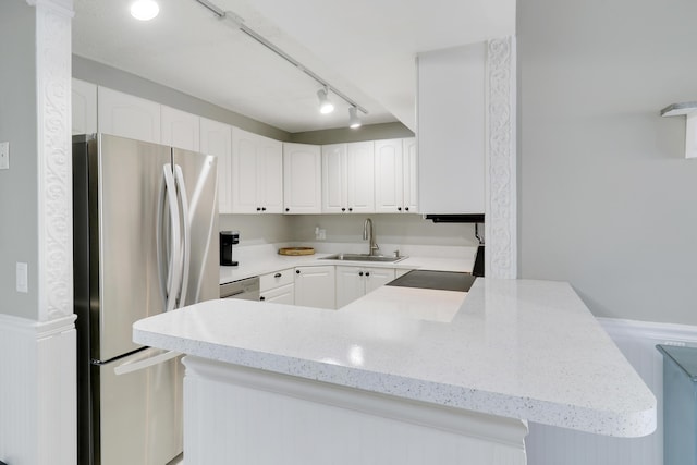 kitchen featuring stainless steel refrigerator, white cabinetry, rail lighting, sink, and kitchen peninsula