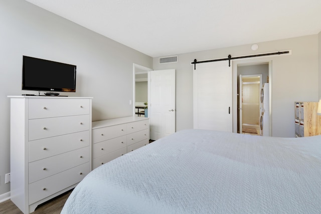 bedroom featuring wood-type flooring and a barn door