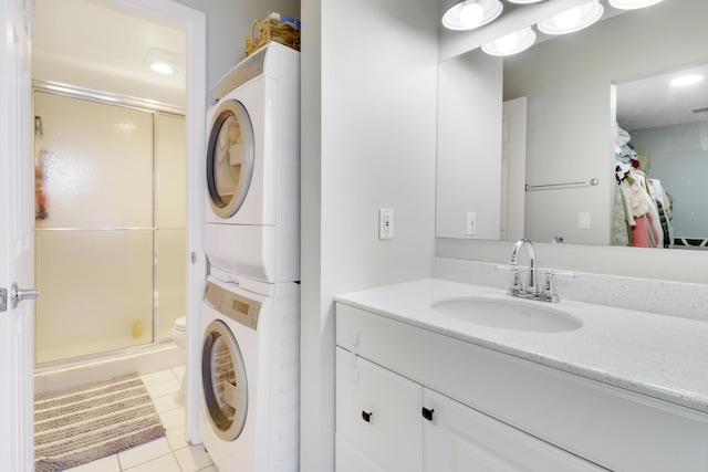 bathroom with stacked washer and dryer, vanity, an enclosed shower, toilet, and tile patterned floors