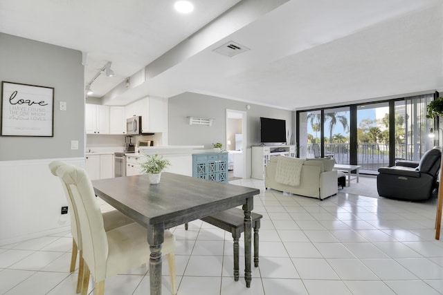 tiled dining space with expansive windows and track lighting