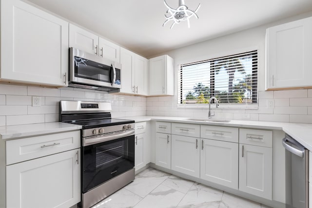 kitchen featuring tasteful backsplash, stainless steel appliances, sink, and white cabinets