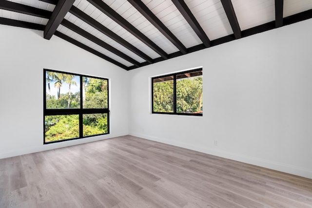 empty room with lofted ceiling with beams and light hardwood / wood-style floors