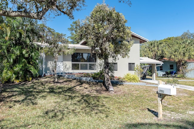 view of front facade featuring a carport and a front lawn